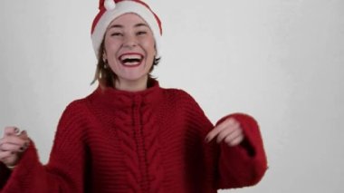 Noel Baba şapkalı genç pozitif kadın beyaz arka planda izole edilmiş. Noel Baba şapkalı mutlu genç kadın. İnsanlar ve kış tatili konsepti