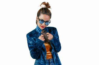 Young woman with glasses on a white background.Charming smiling woman poses against white studio wall. People sincere emotions. Lifestyle concept.