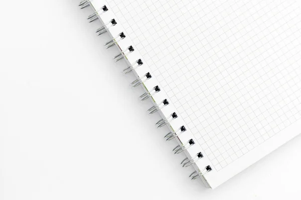Close-up of a notebook with checkered pages. Spiral notebook isolated