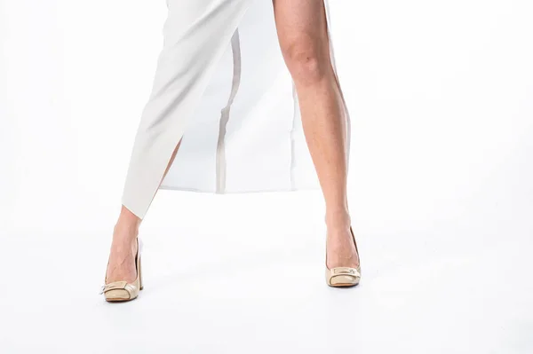 一个身材苗条 穿着白色背景衣服的年轻女子的腿 高跟鞋和女人的衣服和腿假扮成美丽的模特 完美的女人腿 — 图库照片