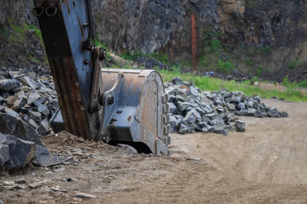 stock image Excavator bucket at basalt quarry. Basalt mining. Excavators in a basalt quarry near the forest. Large excavator in an outdoor mine