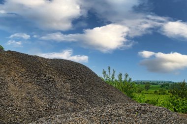 Granitten küçük çakıllar. Taş ocağında büyük bir bazalt yığını..