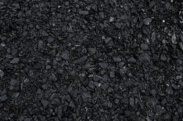 Crushed black stone as a background. Black granite gravel background for mix concrete. Construction rock. Banner design