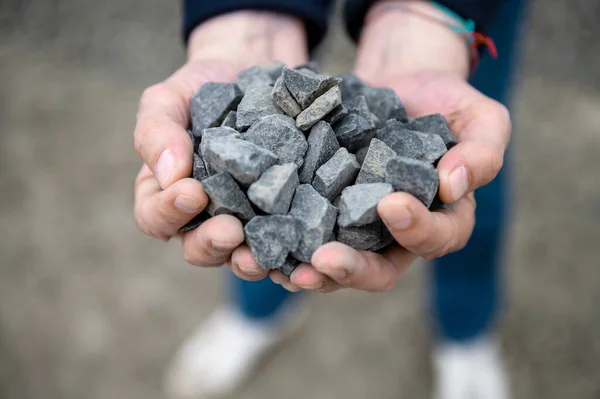 stock image Gravel in the hands of a quarry worker. Worker holding pebbles in hands. Crushed stone quarry in the hands of a man. Selective focus.