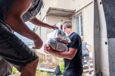 RIVNE, UKRAINE - 18 Haziran 2023. Ukrayna 'ya insani yardım indiriyorum. Ukraynalı gönüllüler içinde insani yardım bulunan kutuları boşaltıyor