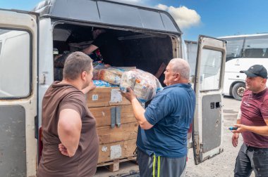 RIVNE, UKRAINE - 18 Haziran 2023. Ukrayna 'ya insani yardım indiriyorum. Ukraynalı gönüllüler içinde insani yardım bulunan kutuları boşaltıyor