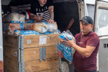 RIVNE, UKRAINE - 18 Haziran 2023. Ukrayna 'ya insani yardım indiriyorum. Ukraynalı gönüllüler içinde insani yardım bulunan kutuları boşaltıyor