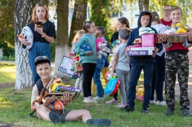 RIVNE, UKRAINE - 27 Temmuz 2023. Ukraynalı çocuklar gönüllülerden hediyeler aldı. Ukrayna 'da insani yardım