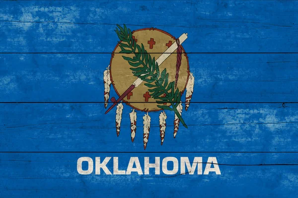 Oklahoma State flag on a wooden surface. Banner of the grunge Oklahoma State flag.