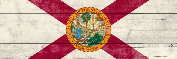 Florida State flag on a wooden surface. Banner of the grunge Florida State flag.