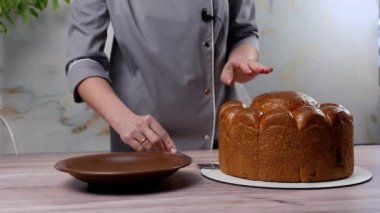 Mutlu Paskalyalar. Kadın bayram için paskalya pastası kesti. Paskalya tatiline hazırlanma konsepti. Beyaz kadın elleri Paskalya pastasını kesti. 