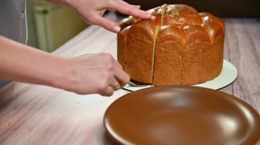 Mutlu Paskalyalar. Kadın bayram için paskalya pastası kesti. Paskalya tatiline hazırlanma konsepti. Beyaz kadın elleri Paskalya pastasını kesti. 