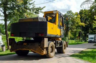 Parktaki sarı traktör. İnşaat malzemeleri inşaat alanına park edilmiş.