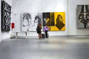 LUTSK, UKRAINE 19 Ağustos 2021. Sanat galerisinde bir grup kız. Sanat galerisinde modern resimlere bakan kız arkadaşlar.