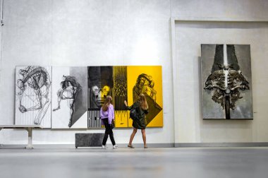 LUTSK, UKRAINE 19 Ağustos 2021. Sanat galerisinde bir grup kız. Sanat galerisinde modern resimlere bakan kız arkadaşlar.