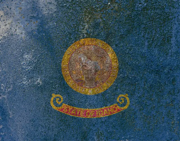 Idaho Eyalet Bayrağı. Paslı metal yüzeyinde kirli Idaho bayrağı. Paslı metal dokusu 