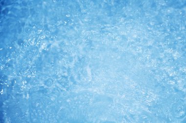 Dalgalı mavi su. Defocus, berrak, durgun su yüzeyi dokusunu su kabarcıkları ve kabarcıklarla bulanıklaştırdı. Su yüzeyi arkaplanı