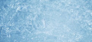 Dalgalı mavi su. Defocus, berrak, durgun su yüzeyi dokusunu su kabarcıkları ve kabarcıklarla bulanıklaştırdı. Su yüzeyi arkaplanı