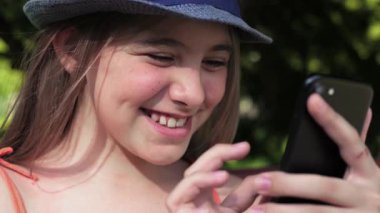 Genç kız sokakta akıllı telefon içeriğini araştırıyor. Genç kız telefonda konuşuyor.. 