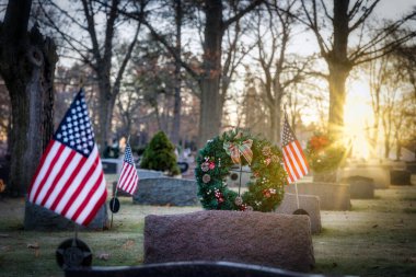 Wisconsin mezarlığında güneş bayraklar ve Noel çelenkleri üzerinde yükseliyor..
