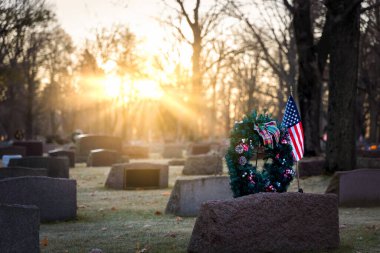 Wisconsin mezarlığında güneş bayraklar ve Noel çelenkleri üzerinde yükseliyor..