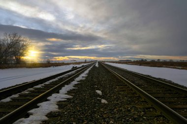 The winter sun sets on the snow covered horizon at Fort Morgan, CO
