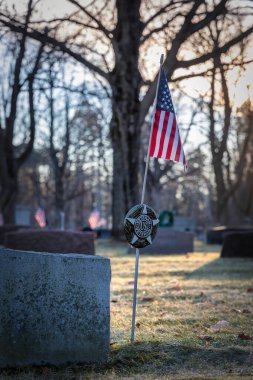 Wisconsin mezarlığında güneş bayraklar ve Noel çelenkleri üzerinde yükseliyor..