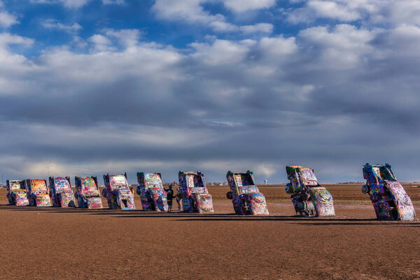 On historic Route 66, the Cadillac Ranch stands near Amarillo, Texas as a public art exhibition of ten Cadillacs buried at the same angle as the pyramids at Giza.  Visitors are also encouraged to spray paint the cars.