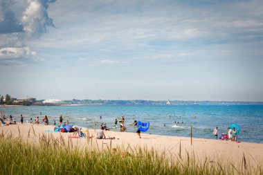 2023 Bağımsızlık Günü, Manitowoc, Wisconsin 'deki Michigan Gölü' ndeki Red Arrow Plajı 'ndaki aileler..