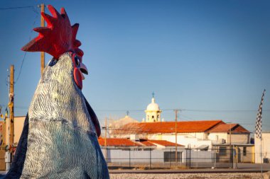 A statue of a rooster sits on the street in Fabens, Texas. clipart