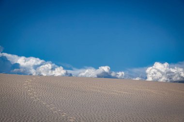 Ayak izleri ufukta beliren bulutlara yol açıyor. Alamogordo, New Mexico yakınlarındaki White Sands Ulusal Parkı 'nda..