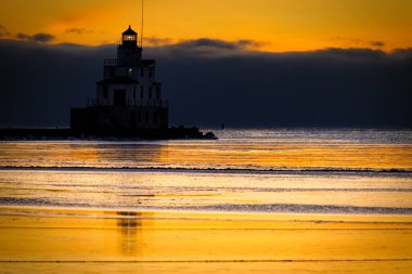 Manitowoc, Wisconsin 'deki donmuş liman ve deniz fenerinde turuncu gökyüzü.