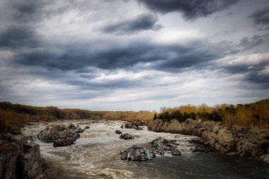 Virginia 'daki Great Falls Ulusal Parkı' nın gürültülü sularının üzerinde bulutlu bir gün..