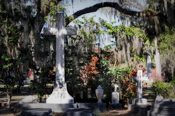 Savannah, Georgia 'daki Bonaventure Mezarlığı' nda İspanyol yosunu, çiçek ve haçlar..