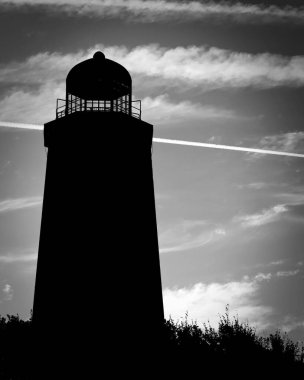 Akşam güneşi Virginia 'daki Virginia Beach' te 1792 'de inşa edilen Cape Henry Deniz Feneri' nin bir siluetini sağlar..