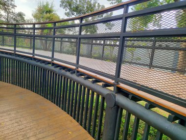 Modern klasik estetik ahşap köprü mimarisinin güzelliği, ormanı uzun ve gür ağaçlarla çevreler.