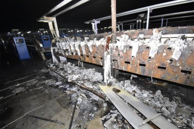 Demir çerçeveler ve erimiş plastik üreten endüstriyel tekstil makinesinin kalıntıları.