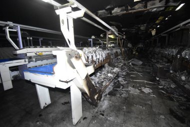 Demir çerçeveler ve erimiş plastik üreten endüstriyel tekstil makinesinin kalıntıları.