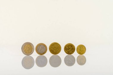 Beyaz bir masanın üzerinde duran bir dizi euro sikkesi