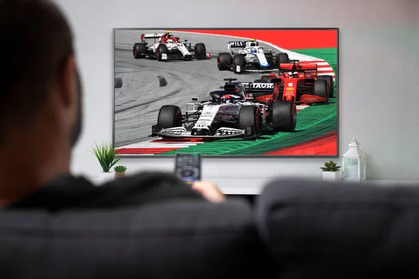 stock image Man watching formula racing on smart TV. Live racing transmission. ROSARIO, ARGENTINA - MARCH 2, 2023.