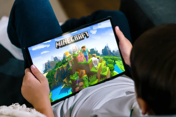 Küçük çocuk tabletle Minecraft oynuyor. Minecraft çocuklar ve gençler arasında çok popüler bir oyundur. Rosario, Arjantin - 20 Kasım 2023.
