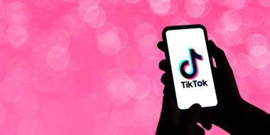 Ekranda Tiktok logosu olan cep telefonu tutan kadın. Eğlence kısa video sosyal ağı. Gençlik konseptiyle illüstrasyon. Yüksek karşıtlık renkleri. Rosario, Arjantin - 13 Aralık 2023.