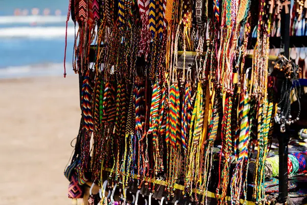 Beach vendor with handcrafted beach style jewelry and colorful bracelets for sale for tourists