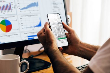 Adam cep telefonu ve dizüstü bilgisayarda Sheets uygulaması kullanıyor. Google Çalışma Alanı, çevrimiçi dijital üretkenlik araçları. ROSARIO, ARJANTINA - 20 Şubat 2024.