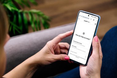 Ekranda ChatGPT olan cep telefonu kullanan bir kadın. Bu uygulama, OpenAI tarafından geliştirilen Yapay Zeka tabanlı bir sohbet robotu. ROSARIO, ARJANTINA - 20 Şubat 2024