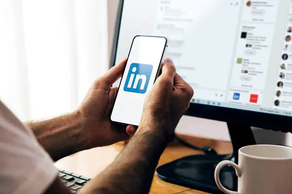 Akıllı telefon ekranında linkedIn uygulaması. Profesyonel ve iş odaklı sosyal hizmetler uygulaması olan bir telefon tutan adam. ROSARIO, ARJANTINA - 18 Mart 2024.