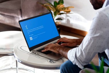 Dizüstü bilgisayarlı bir adam mavi ekranı ya da ekranda BSOD 'u gösteriyor. Hatalı Microsoft işletim sistemi Windows 10. Rosario, Arjantin - 19 Temmuz 2024.