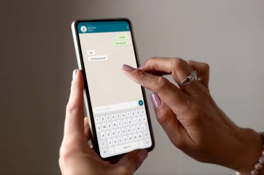 Elinde telefon olan ve ekranda sohbet uygulaması olan bir kadın. İletişim Teknolojisi, uygulama.