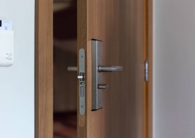 Elektronik kilidi olan ahşap kapı. Elektronik anahtarlı giriş kapısı var. Manzarayı kapat. Resmi dikey biçimlendir.