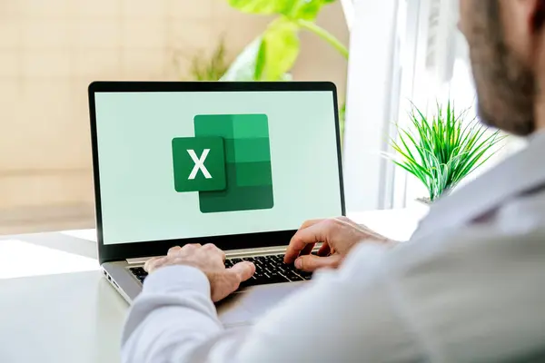 Ekranda Microsoft Excel 'in logosunu gösteren bir dizüstü bilgisayar kullanan adam. Hesaplama, formüller ve verimlilik için hesap tablosu yazılımı. ROSARIO, ARJANTINA - 18 Ekim 2024.